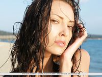 Загорелая брюнетка с маленькими сиськами раздевается на пляже