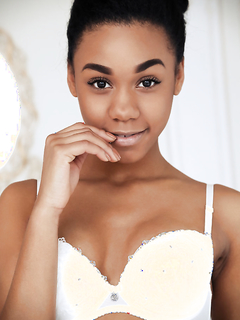 Смазливая мулатка в чулках показывает киску в своей комнате